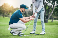 Golftrainingsreise- a man holding a golf club and another man holding a golf club